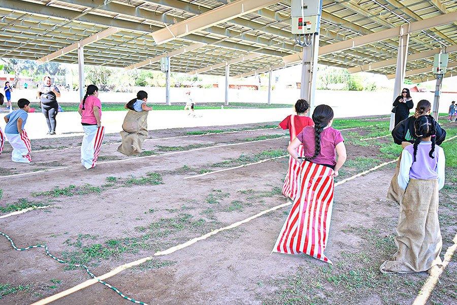 Students hop across the field in sacks