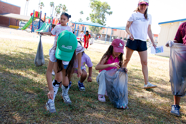 A group of girls pick up trash on the school campus