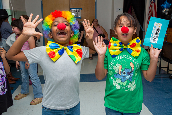 Two students dressed as clowns smile for a photo