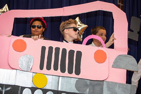 Students dance behind a pink Jeep cutout